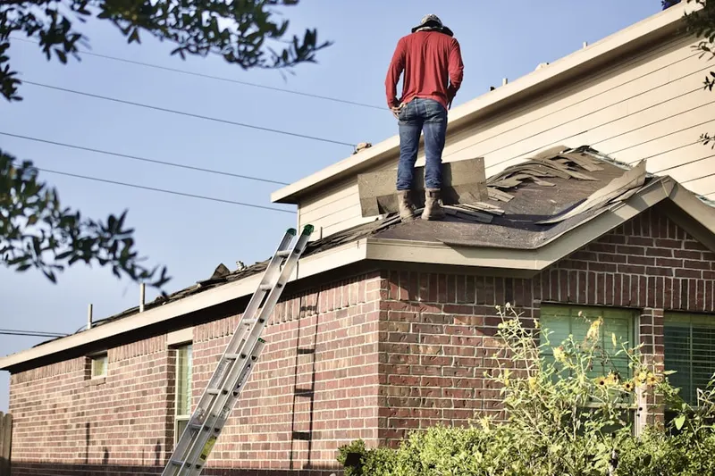 Professional roofer working on a residential roof in West Roxbury